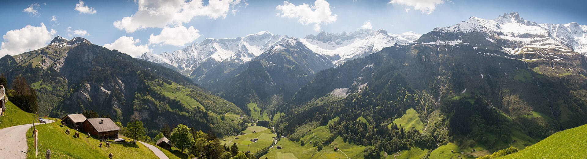 The Sernftal valley near Elm, Switzerland — snow-capped peaks above forested slopes and the valley floor.